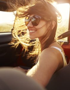 A young woman smiling in the sunshine.