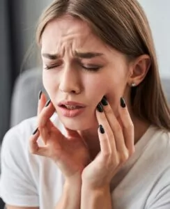 A young woman experiencing oral pain.