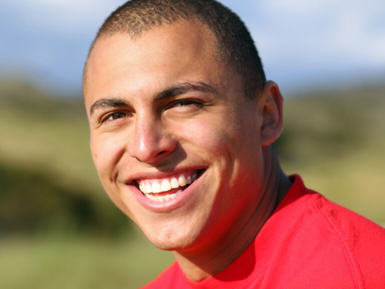 A young man smiling confidently after teeth whitening treatments.
