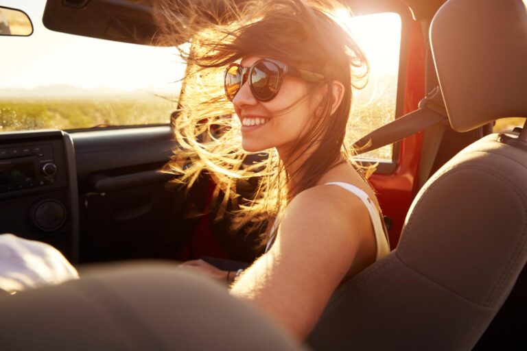 A young woman smiling in the setting sun, free of dental anxiety.