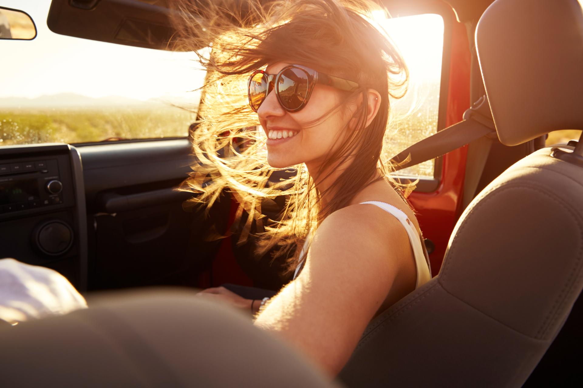 A young woman smiling in the setting sun, free of dental anxiety.