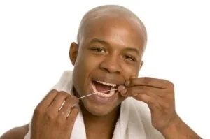A man flossing his teeth to prevent gum disease.