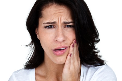 A young woman clutching her jaw in need of a root canal in Kennesaw.