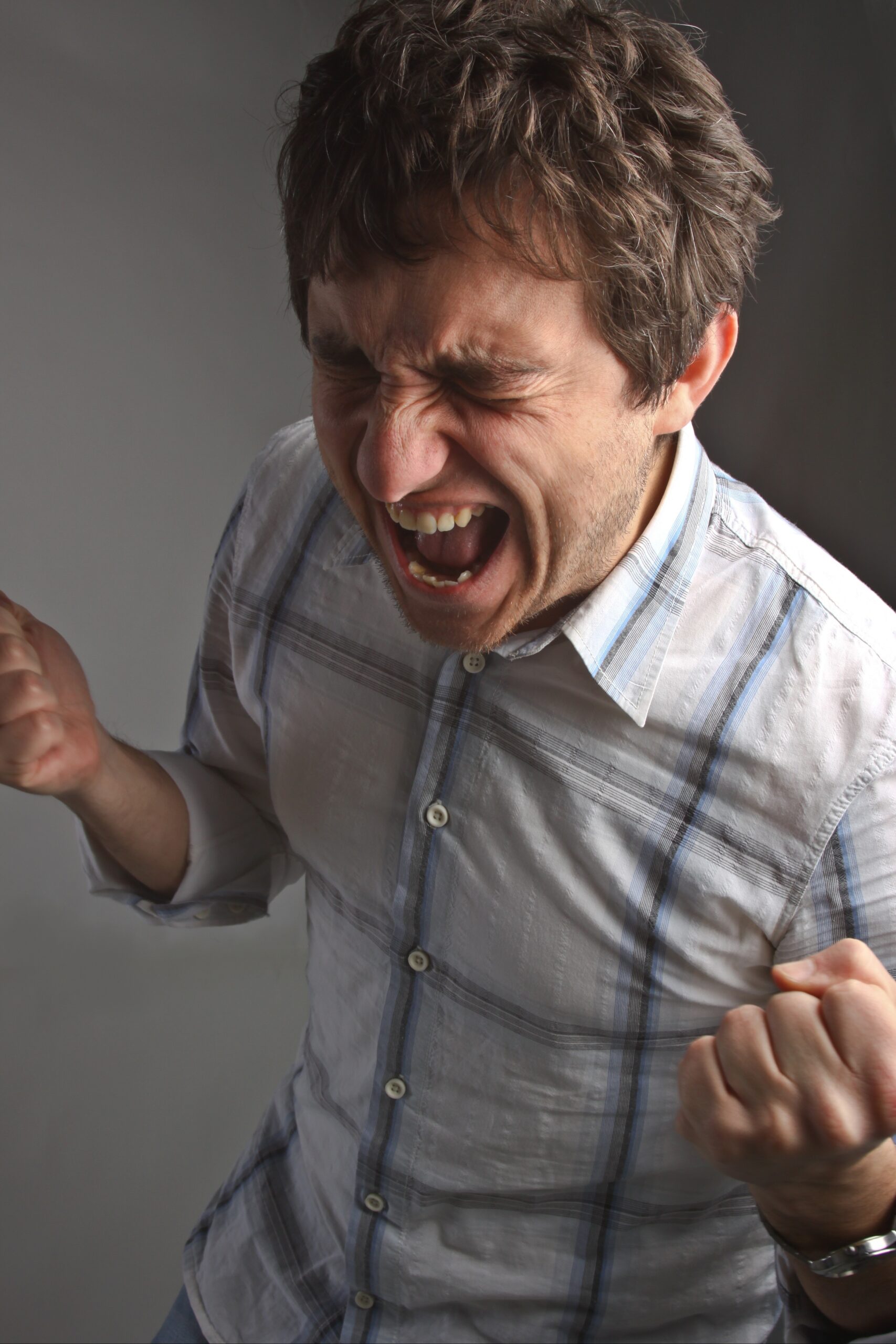 A man screaming in irritation out of pain from untreated TMJ in Kennesaw.